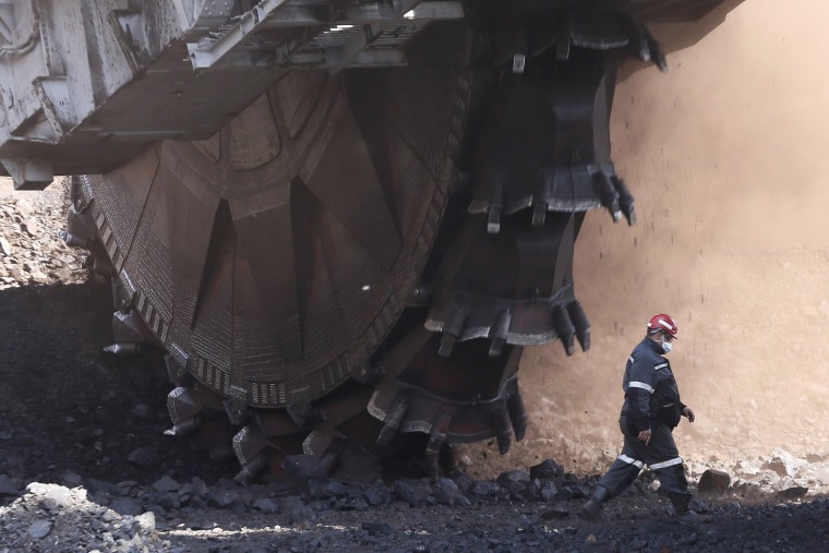 Image: An employee walks past a Soviet-made rotary dredge