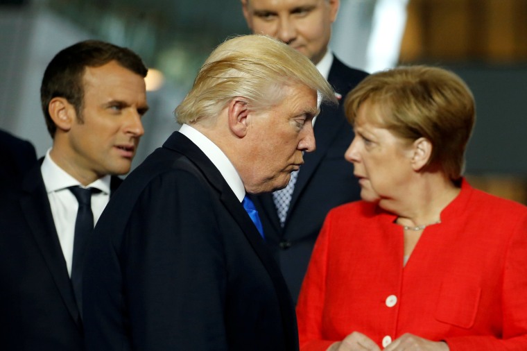 Image: President Donald Trump walks past French President Emmanuel Macron (L) and German Chancellor Angela Merkel on his way to his spot for a family photo during the NATO summit at their new headquarters in Brussels, Belgium, May 25, 2017.