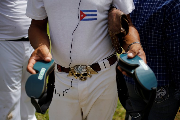 Image: Filiberto Socarras, who is visually impaired, holds googles during a baseball lesson at the Changa Medero stadium, in Havana