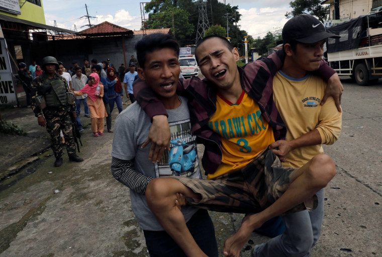 Image: A displaced resident is helped from Marawi City, Philippines.