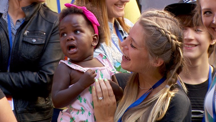 Lauren Rhett holds Willa as the little girl listens to dad perform.