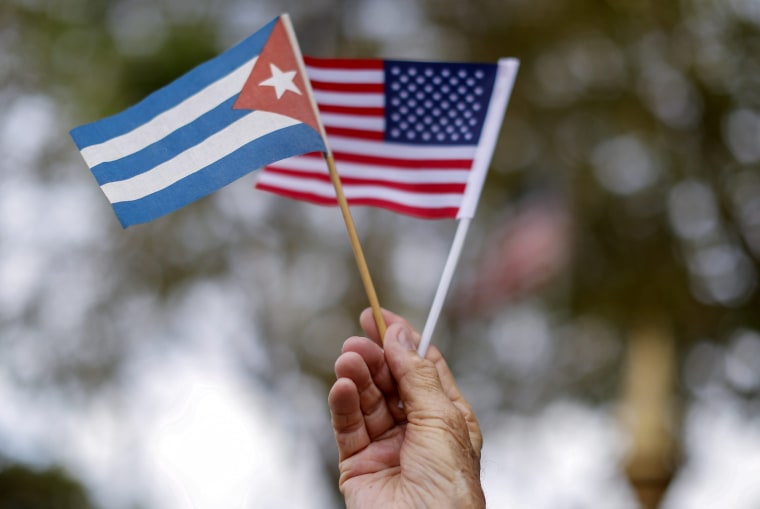 Image: A man holds Cuban and U.S flags in the Little Havana neighborhood of Miami, Florida on March 20, 2016.