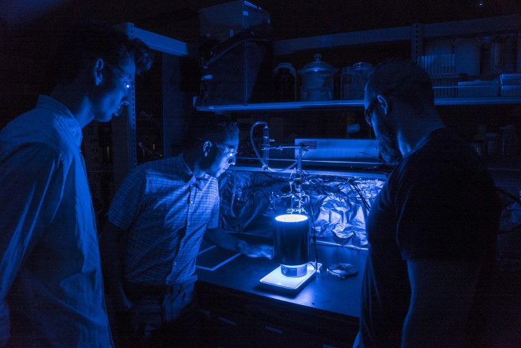 University of Central Florida Assistant Professor Fernando Uribe-Romo, center, has found a way to trigger the process of photosynthesis in a synthetic material.