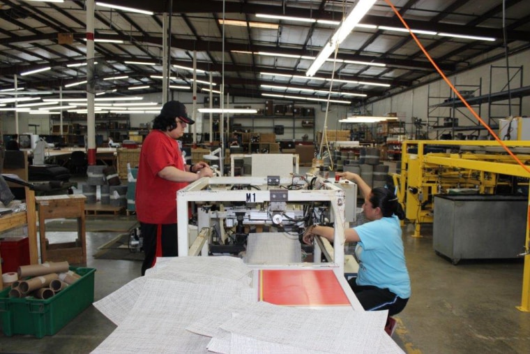 Image: A worker guides the creation of high-end vinyl at a textile factory in Murray County, Georgia