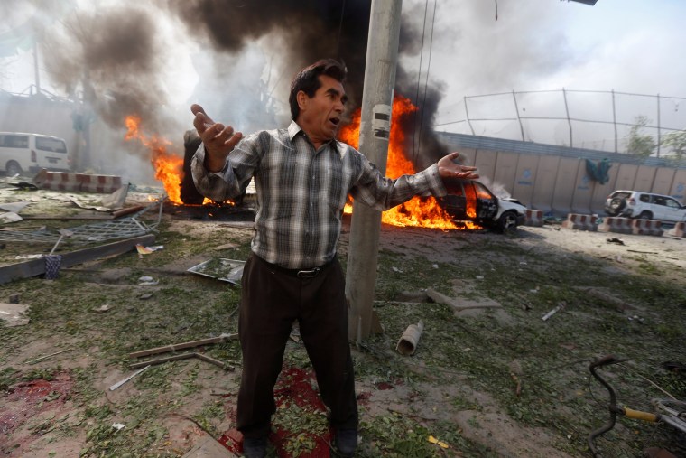 Image: An Afghan man reacts at the site of a blast in Kabul, Afghanistan