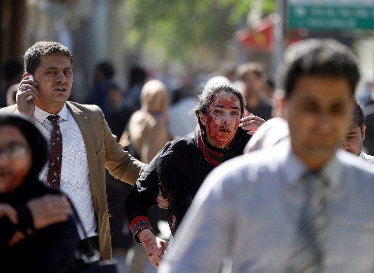 Image: Injured Afghans run from the site of a blast in Kabul, Afghanistan