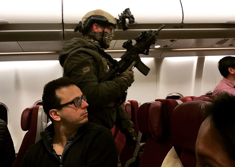 Image: An armed tactical officer sweeps a Malaysia Airlines flight at Melbourne Airport in Australia on Wednesday