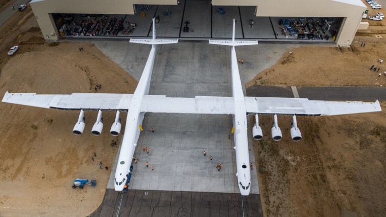 The carrier plane rolls out of its Mojave Air and Space Port hangar for the first time
