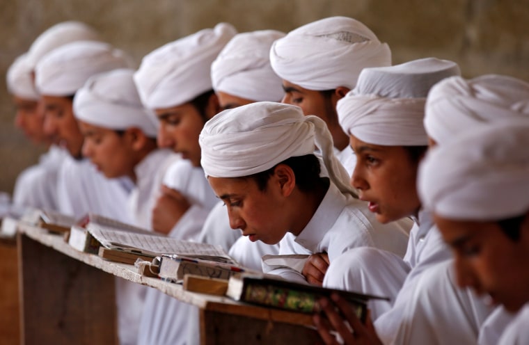 Image: Boys read the Koran inside Markaz Al-Madrasa Al-Islamia, an Islamic seminary and orphanage, during the Muslim fasting month of Ramadan in Shadipora