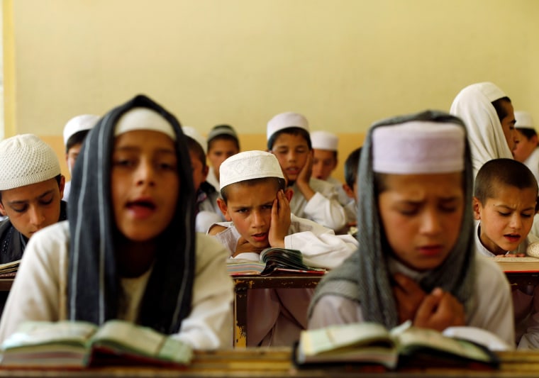 Image: Afghan boys read the Koran in a madrasa, or religious school, during the Muslim holy month of Ramadan in Kabul
