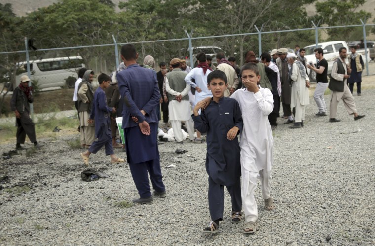 Image: Boys walk away from the site of the three suicide attacks.
