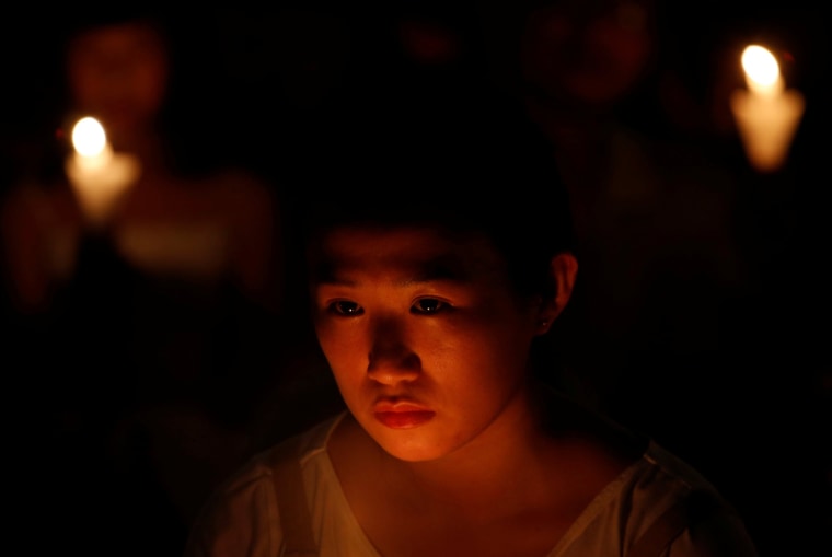 Image: A girl takes part in a candlelight vigil in Hong Kong
