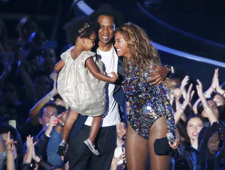 Image: Beyonce smiles with Jay-Z and daughter Ivy Blue after accepting the Video Vanguard Award on stage during the 2014 MTV Video Music Awards in Inglewood