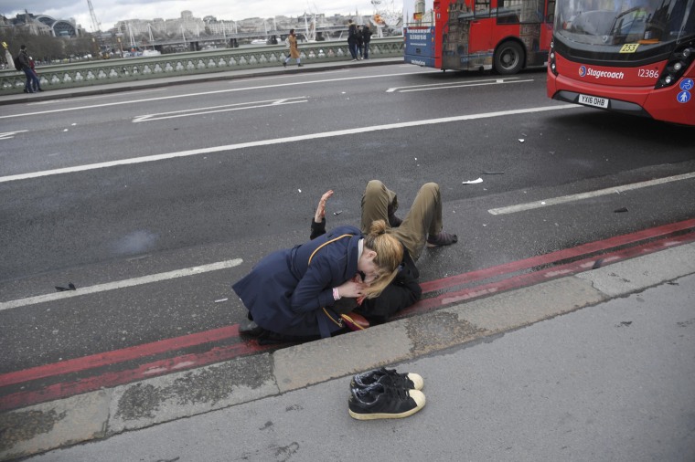 Image: A woman assists an injured person on Westminster Bridge in London