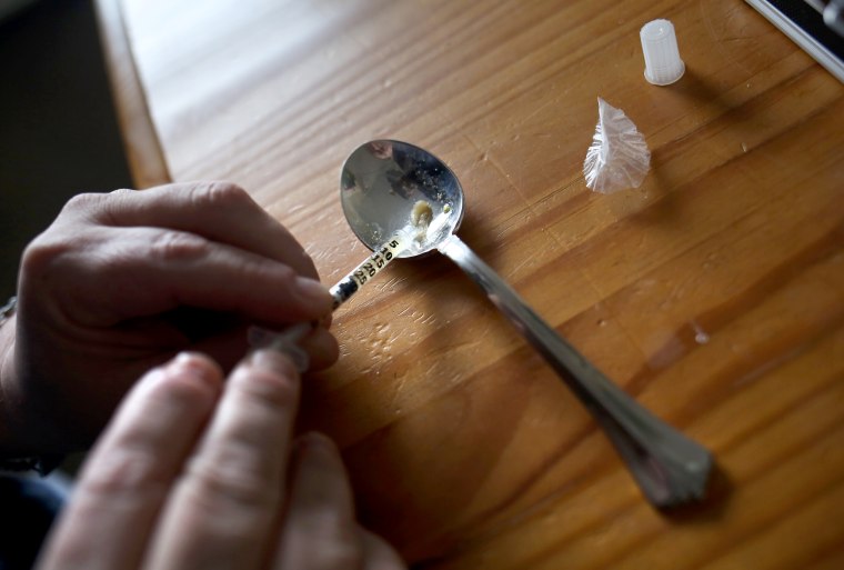 Image: A heroin user prepares to inject himself 