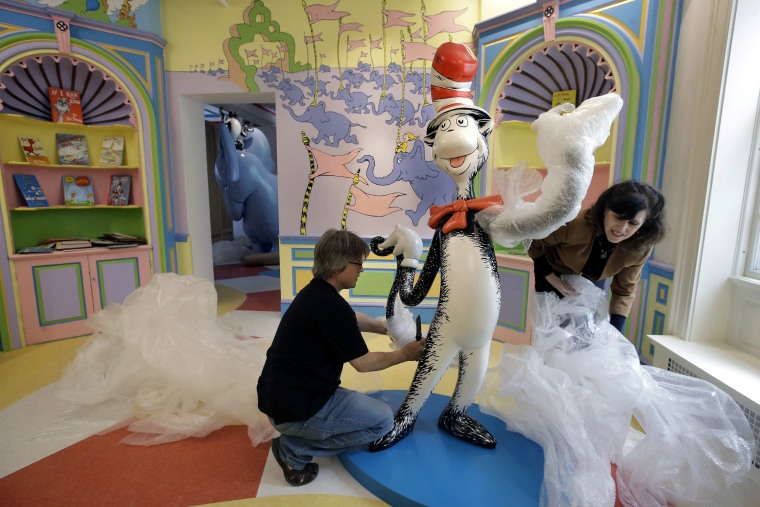 Image: John Simpson, left, project director of exhibitions for The Amazing World of Dr. Seuss Museum, and his wife Kay Simpson unwrap a statue