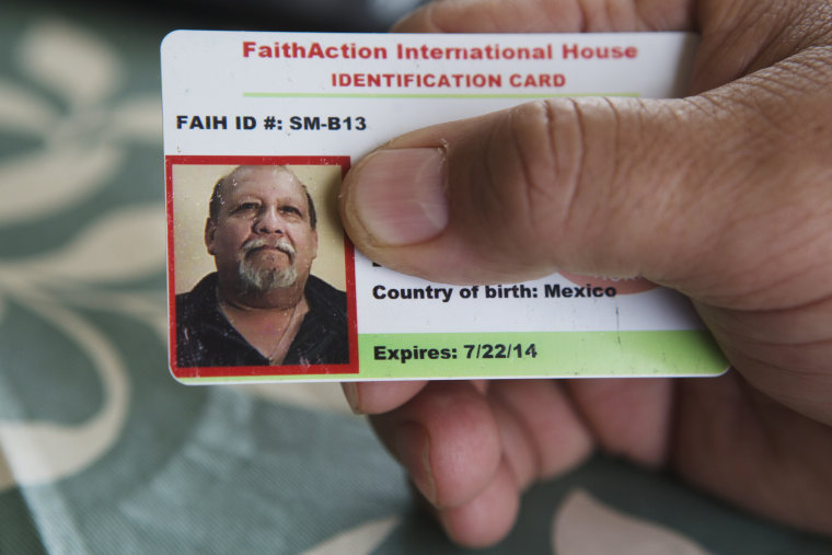 Image: Raul Garcia holds his FaithAction ID card