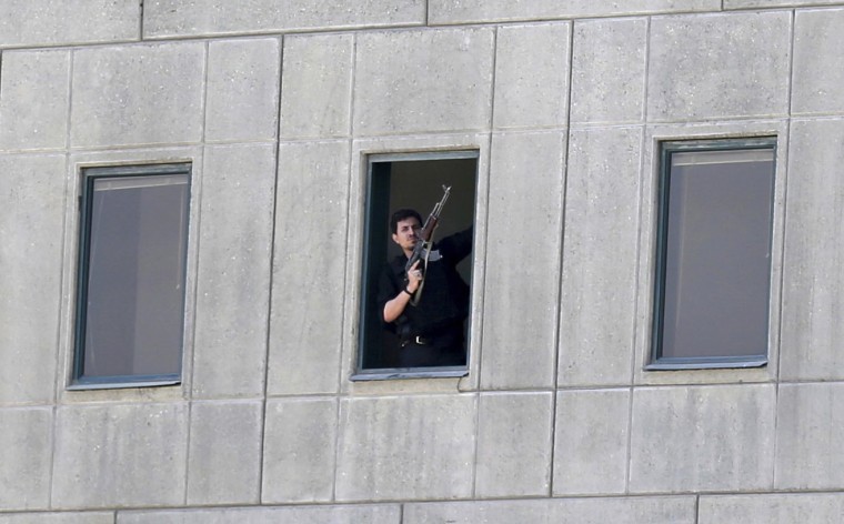Image: An armed man stands in a window of the parliament building in Tehran