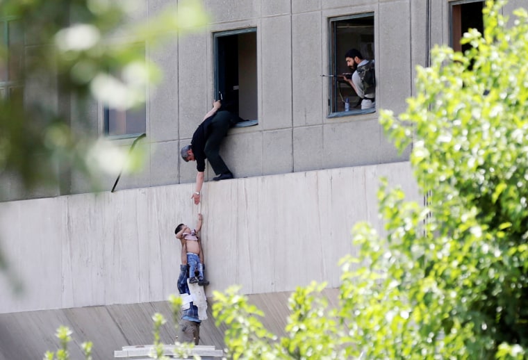 Image: Boy is evacuated during an attack on the Iranian parliament in central Tehran