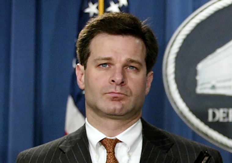 Image: Christopher Wray listens during a press conference at the Justice Department in Washington