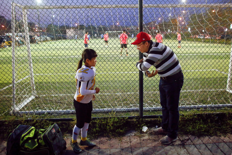 Image: Li of the Eagles listens to her father before she plays the Sharklets