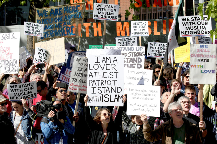 Image: Counter-protesters hold signs and shout slogans during an anti-Sharia rally in Seattle