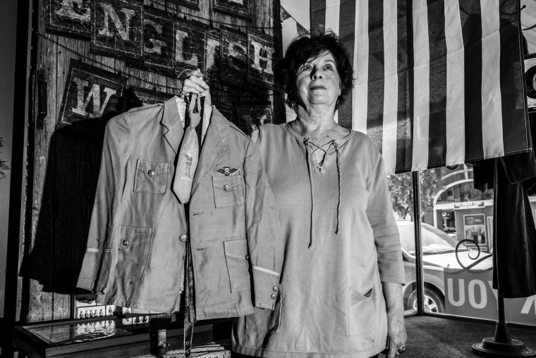 Image: Donna Selk, of Anamosa, holds the uniform her husband wore as a child as she talks about how she thinks Trump's presidency is going so far.