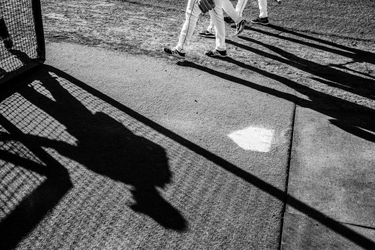 Image: Shadows cast by members of a Cedar Rapids minor league baseball team named the Kernals as they play a game.