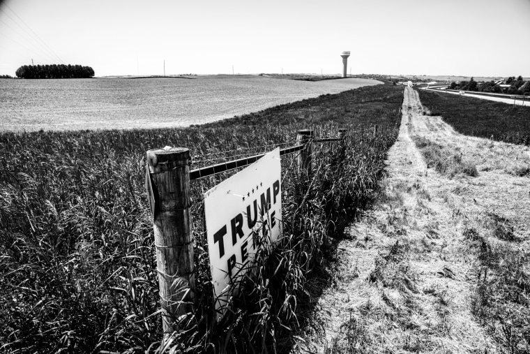 Image: A Trump Pence sign still hangs on a gate in a farm field.