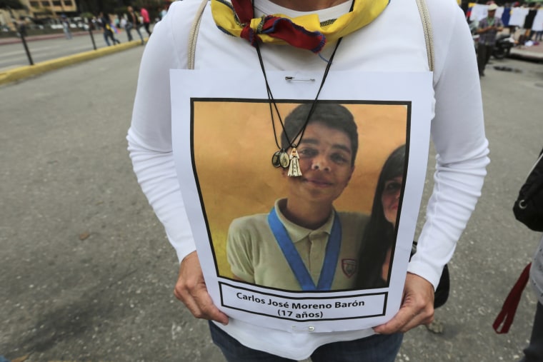 A woman carries a portrait of a person who died in past protests during a march towards the Ombudsman's Office in protest of President Nicolas Maduro in Caracas, Venezuela, Monday, May 29, 2017.