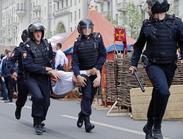 Image: Russian police officers carry a detained participant of an unauthorized opposition rally