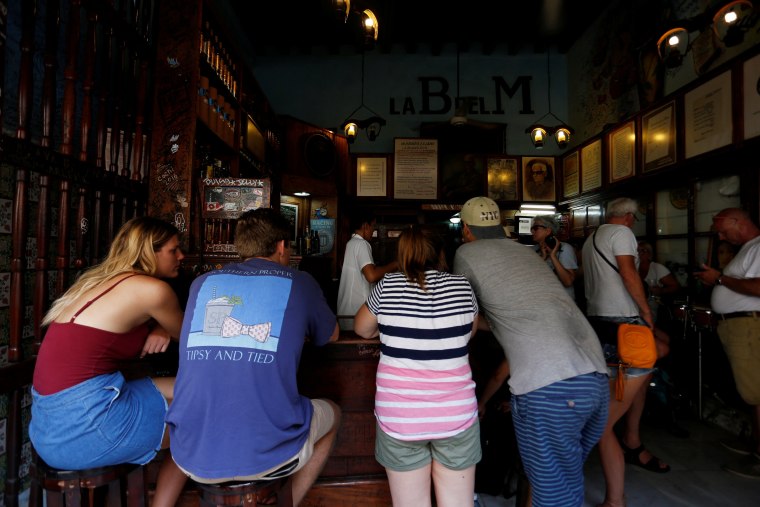 Image: People have drinks at a bar in Havana