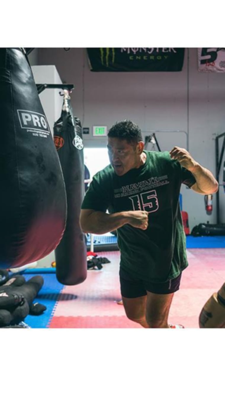 Colin Oyama, head coach at his Team Oyama MMA training center, practicing with a bag.