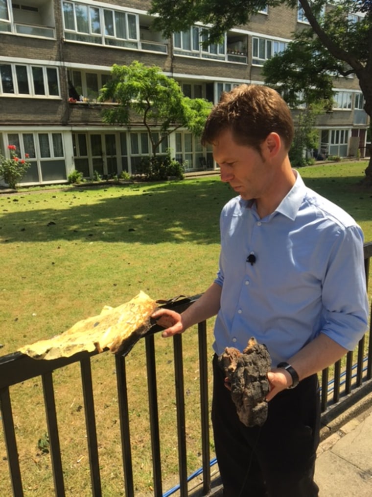 Image: ITV News' Nick Wallis holds chunks of the building's outer layer that rained down during the fire.