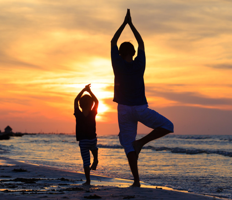 Image: Father and son practice yoga together at sunset