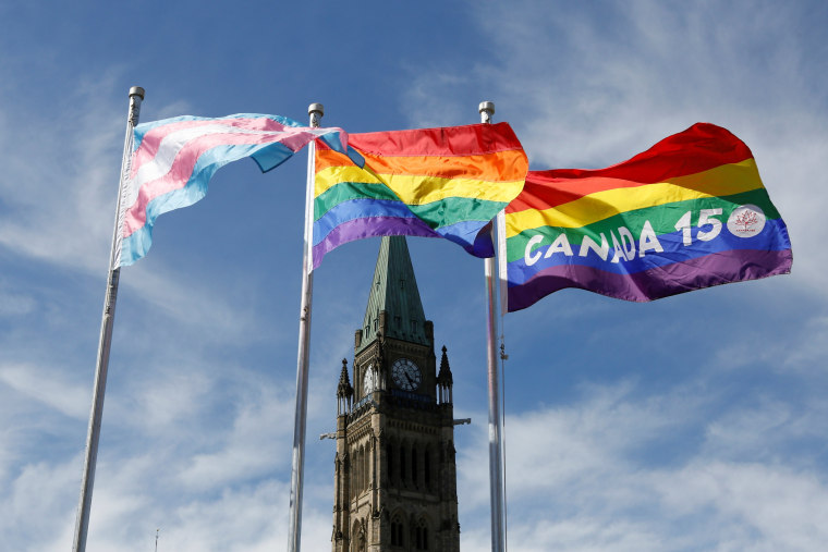 Image: The transgender pride, pride and Canada 150 pride flags fly on Parliament Hill in Ottawa