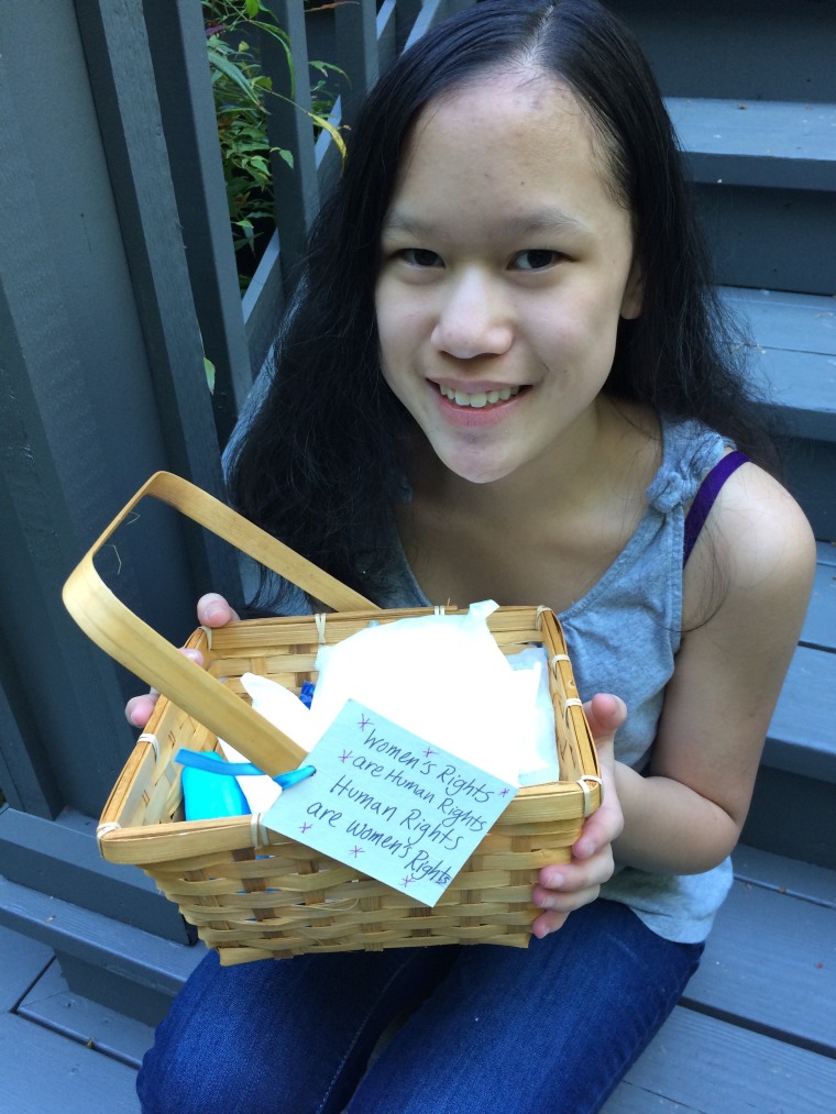 Cordelia Longo sitting on the steps, holding one of the baskets she made with the tag "Women's Rights are Human Rights. Human Rights are Women's Rights." Cordelia Longo says she sees Hillary Clinton as a role model.