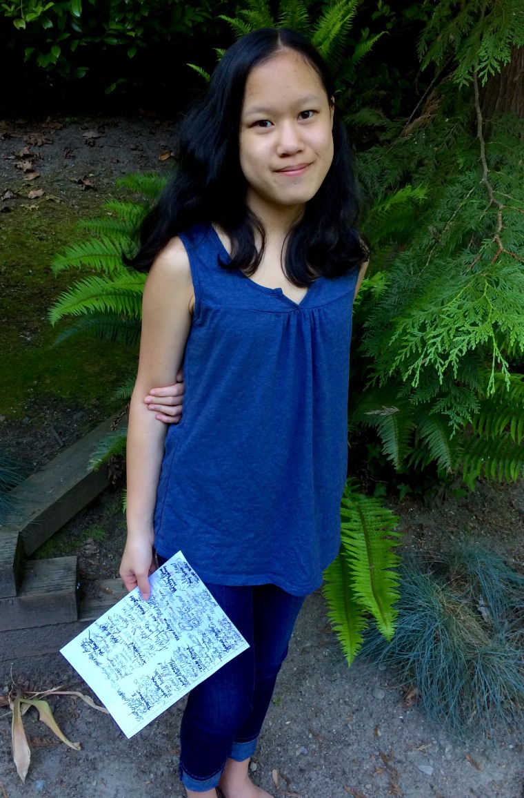 Cordelia Longo holding a mock copy of the petition she drafted to Islander Middle School.