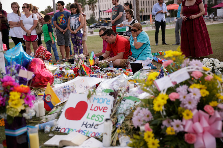ORLANDO, FL - JUNE 14:  People visit the makeshift memorial for the victims of the Pulse Nightclub shooting lay at a makeshift memorial, June 14, 2016 in Orlando, Florida. The shooting at Pulse Nightclub, which killed 49 people and injured 53, is the wors