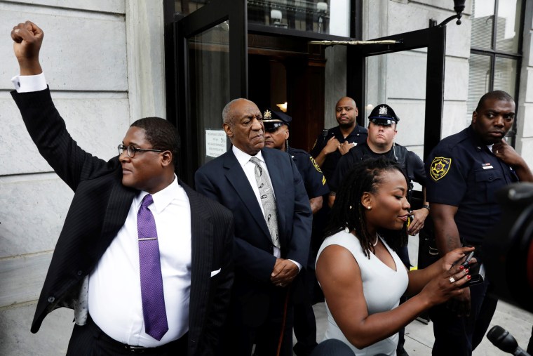 Image: Actor and comedian Bill Cosby stands as his publicist Andrew Wyatt raises his fist after a judge declared a mistrial in Cosby's sexual assault trial at the Montgomery County Courthouse in Norristown, Pennsylvania, June 17, 2017.