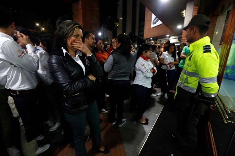 Image: People stand outside the Andino shopping center after an explosive device detonated in a restroom, in Bogota