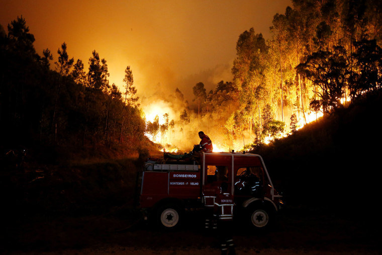 Image: Firefighters work to put out a forest fire near Bouca in central Portugal