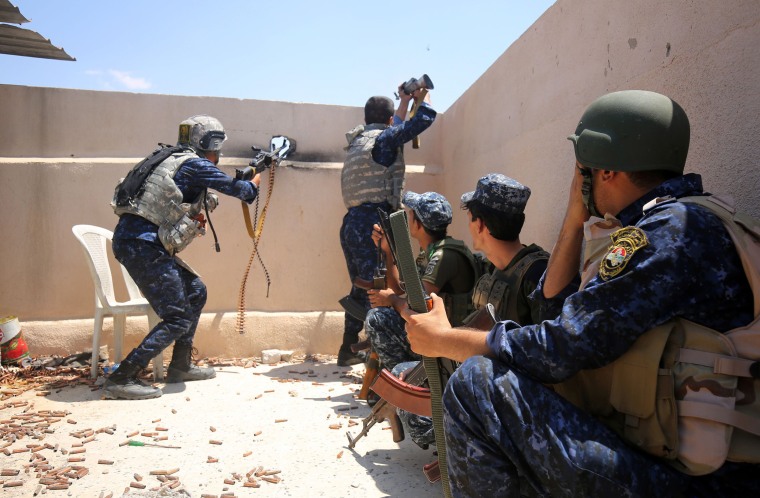 Image: Iraqi forces take a position on the roof of a building as they advance towards Mosul's Old City