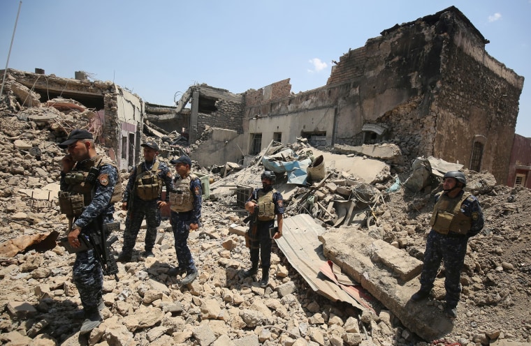 Image: Iraqi forces stand amidst the rubble of a building as they advance towards Mosul's Old City