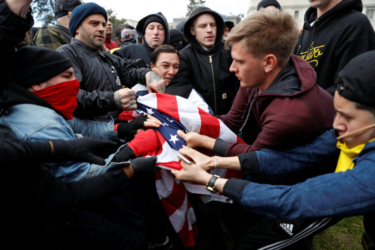 Counter-demonstrators (L) and supporters (R) of U.S. President Donald Trump fight for a U.S. flag during a \"People 4 Trump\" rally in Berkeley, California