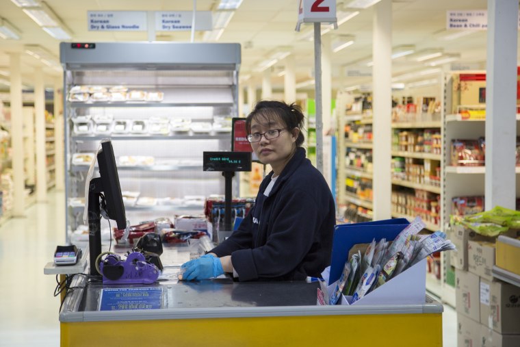 Image: A cashier at the Korea Foods superstore in New Malden