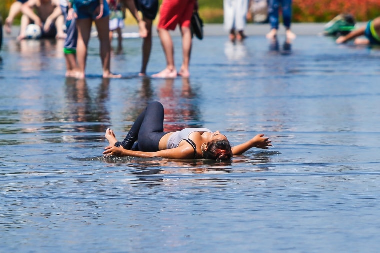 Image: A woman lies down in a reflective pool