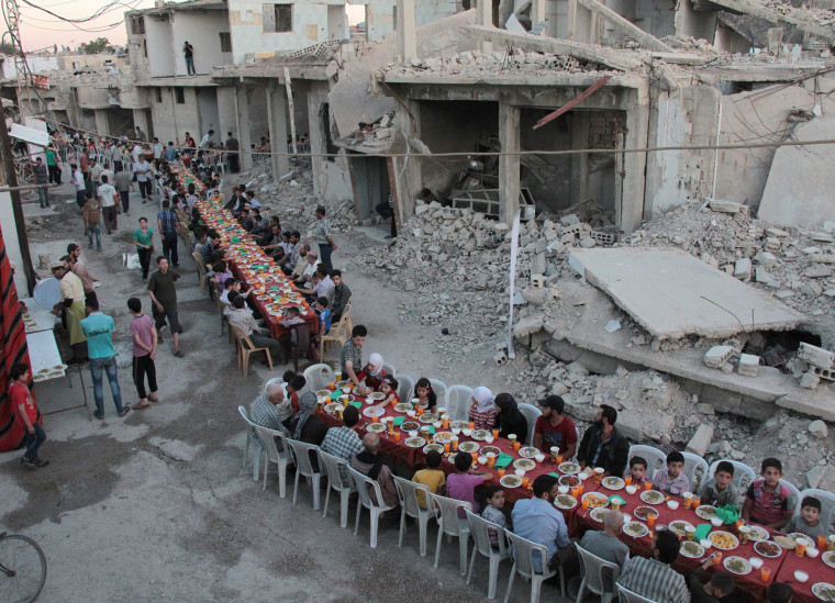 Image: Residents of the rebel-held town of Douma break their fast