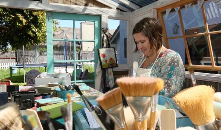 Jenny Karp paints wooden greeting cards for her small business, Glitterfarm, in her "She Shed" in San Luis Obispo, California.