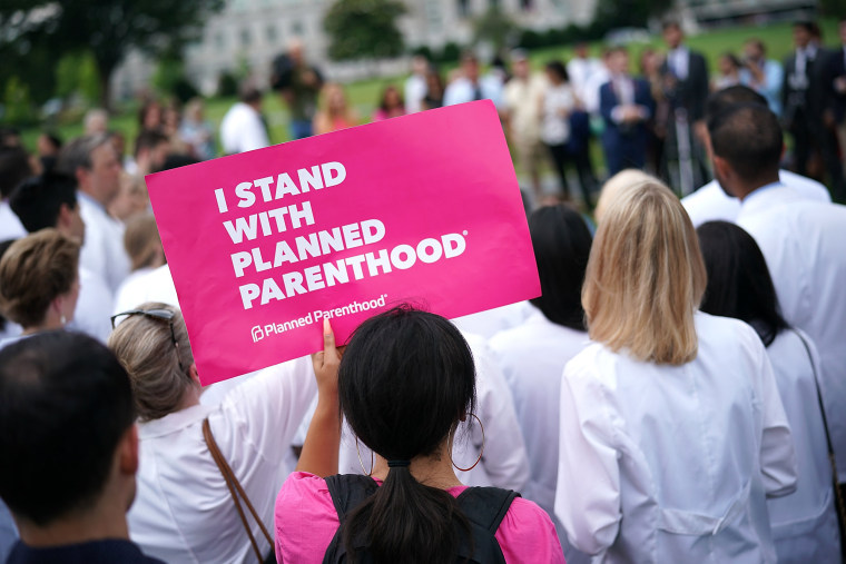 Image: A woman holds a sign as health care providers hold a news conference outside the U.S. Capitol